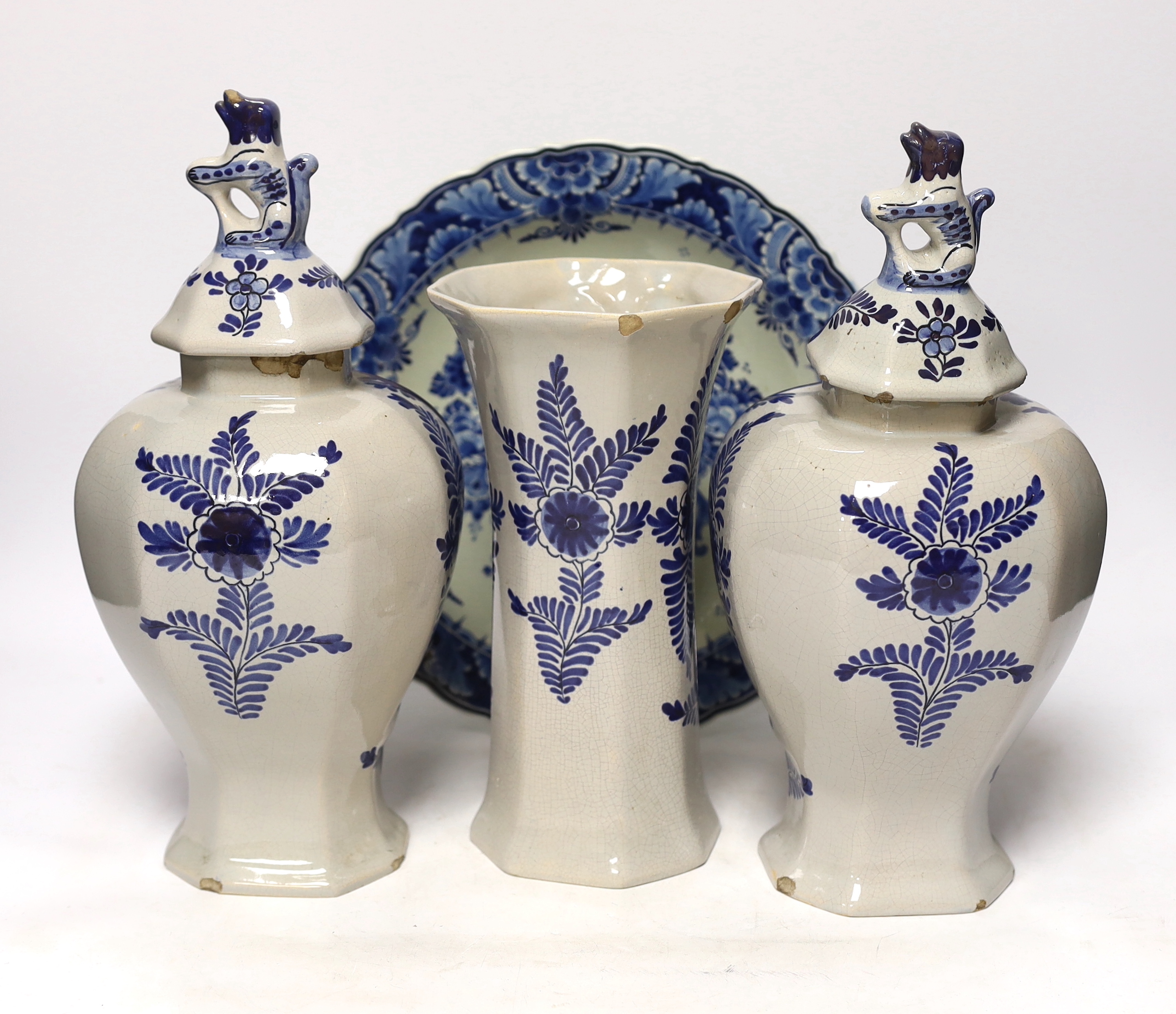A late 18th century Delft garniture of three vases, two with covers, 32cm, together with a modern Delft plate